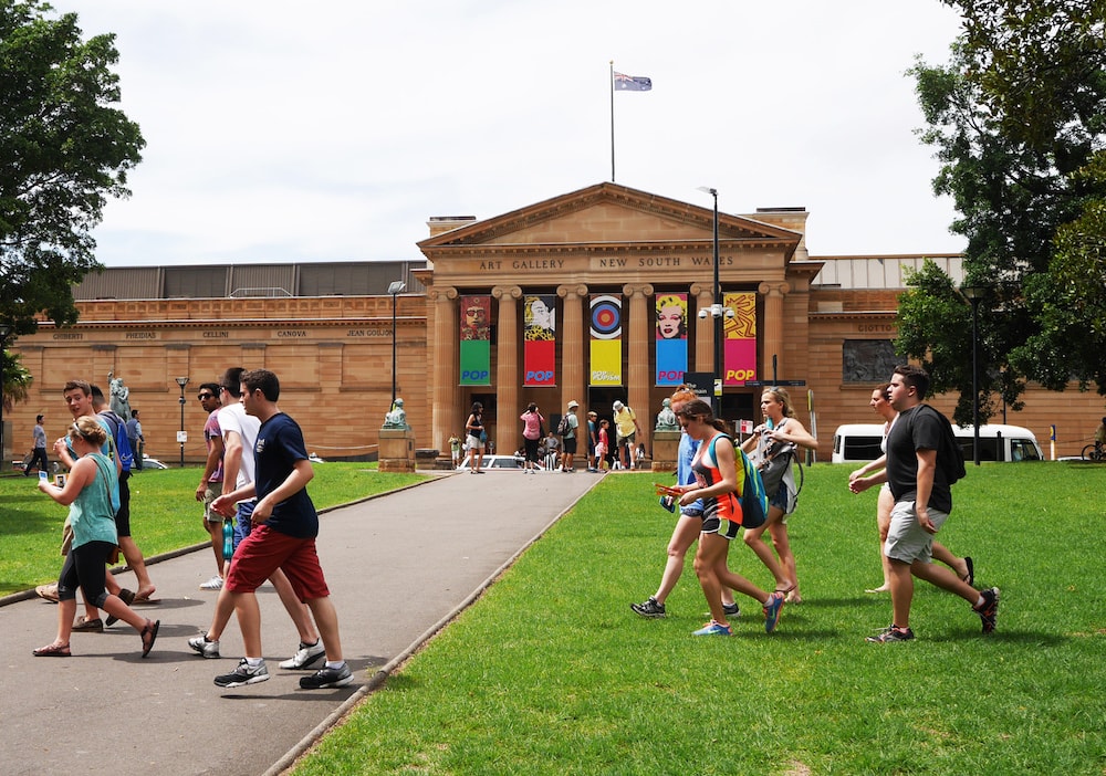 Groups of people walking on the lawn outside the New South Wales Art Gallery