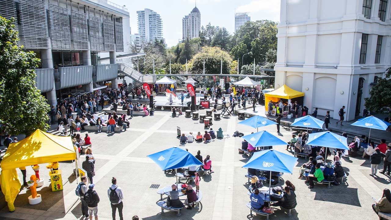 People mill about a central outdoor area on AUT's campus on a sunny day