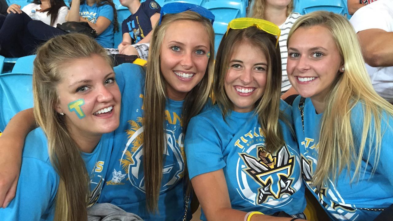 Four women smiling and dressed in school spirit attire