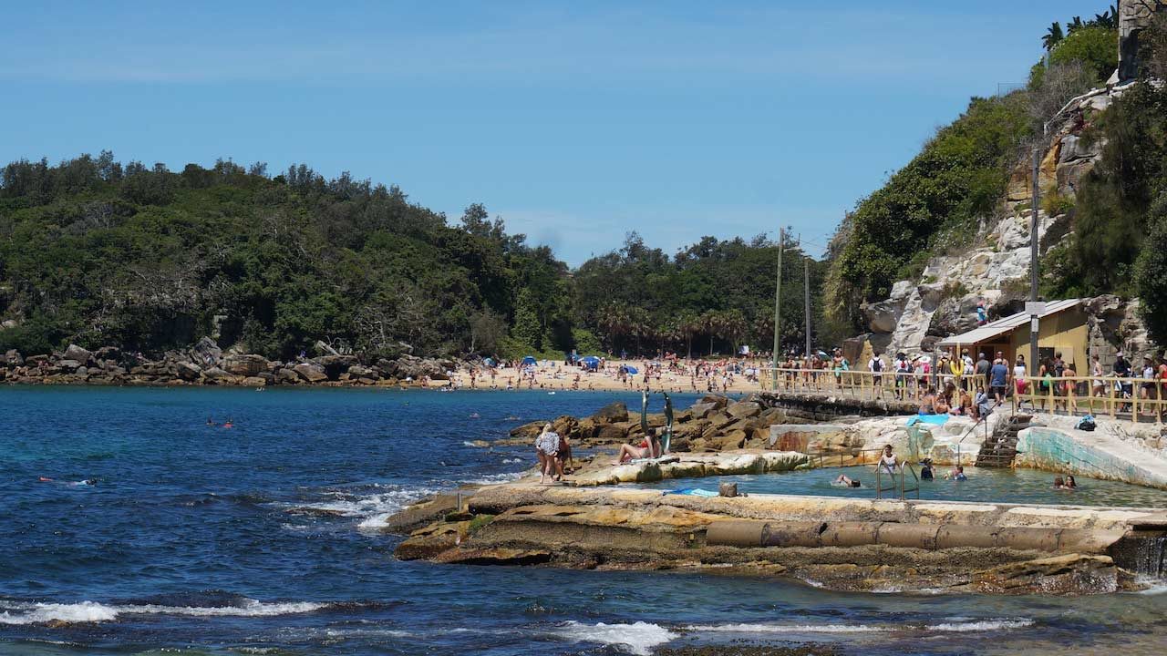 The shore at Manly Beach dotted with sunbathers