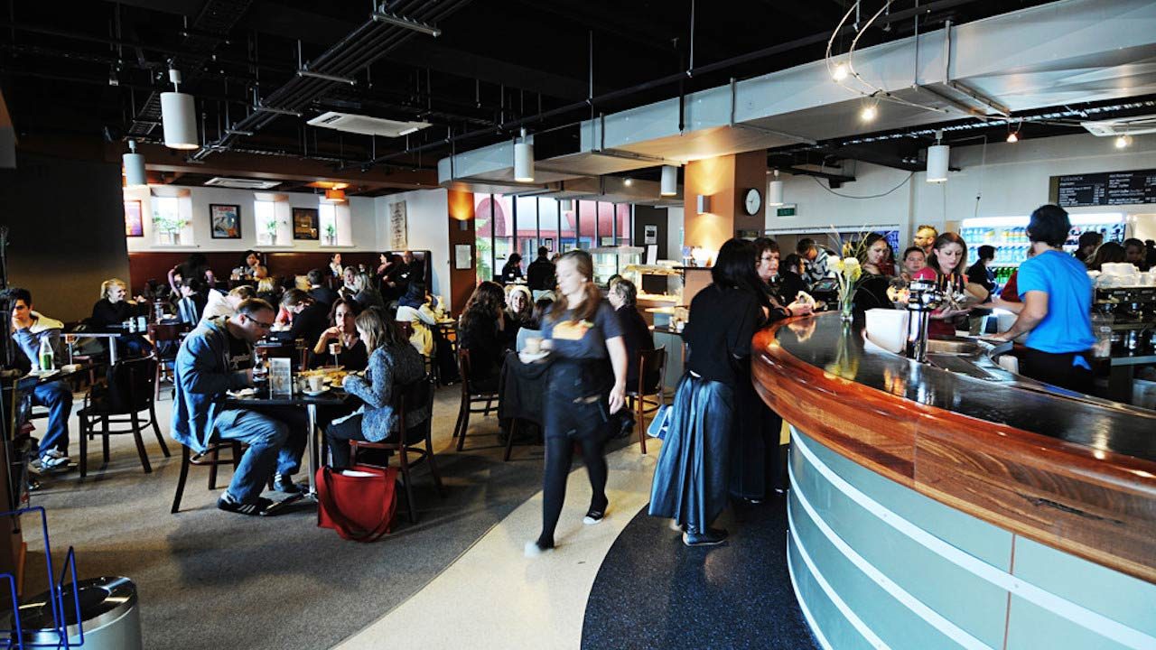 People sit at tables and order at an on-campus dining hub at Massey University Wellington