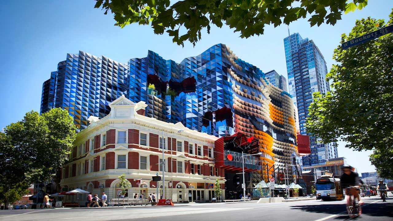 A biker riding past a corner of Melbourne that's home to RMIT's urban campus