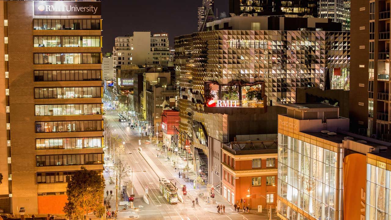 Illuminated buildings and street in downtown Melbourne at night