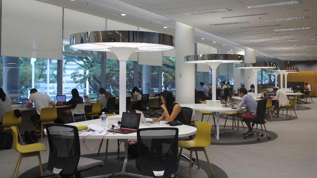 Students sit at round tables in a study room on Singapore Management University's campus