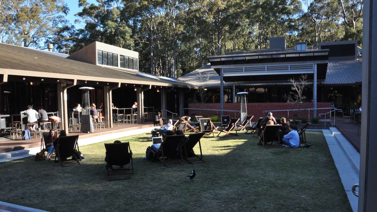 People sit in lawn chairs scattered about the student center's quad on University of Newcastle's campus