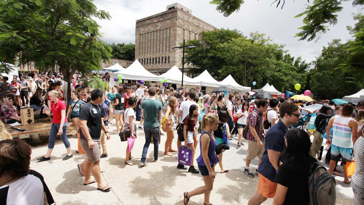 Many students walk around outside in UQ's campus enjoying Orientation Market Day