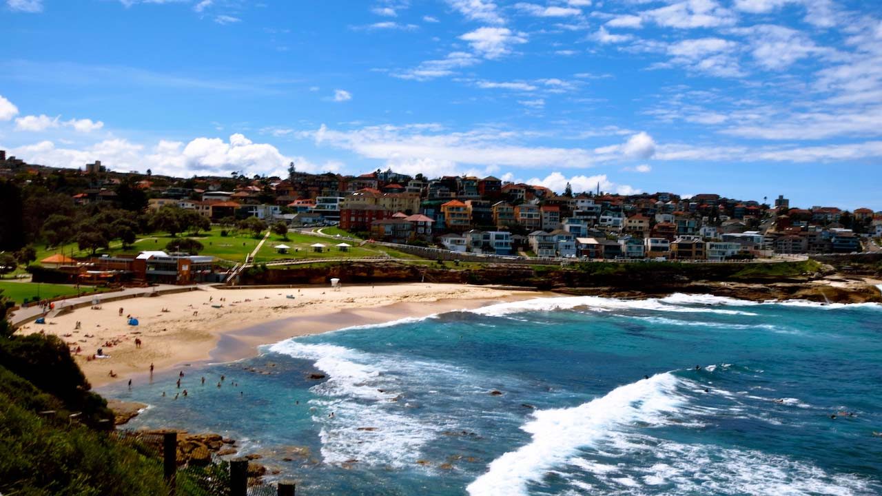 Waves crashing into the shore at the beach in Sydney on a sunny day