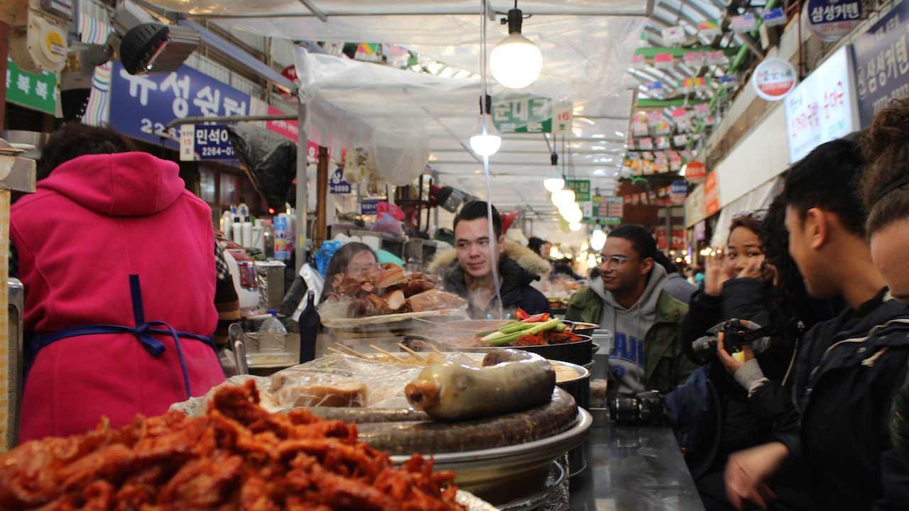 People stand around a stall inside a food court in Korea