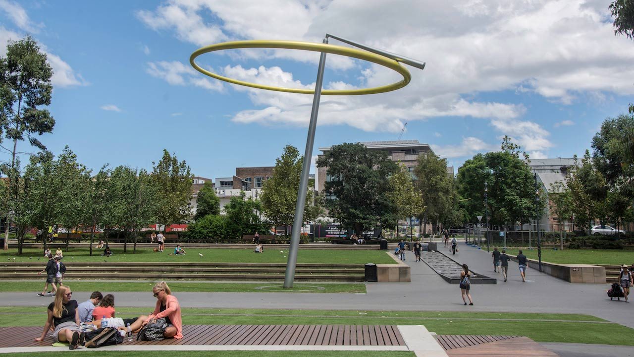 People sit, walk around and enjoy the park on University of Technology Sydney's campus