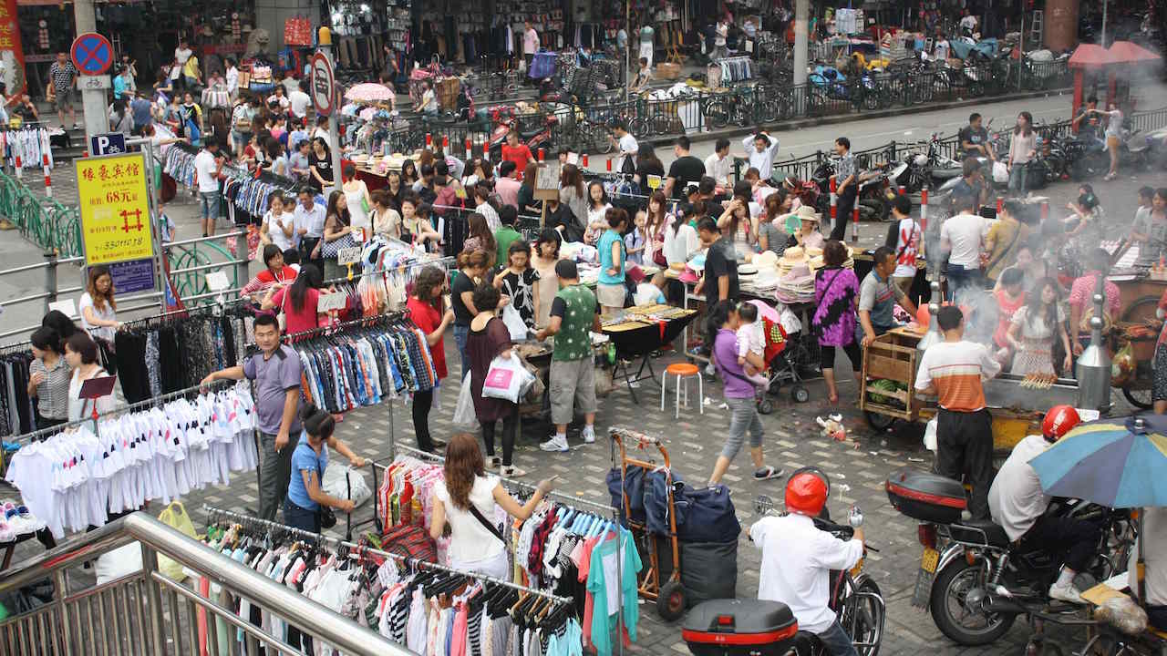 A crowded outdoor clothing market in Shanghai